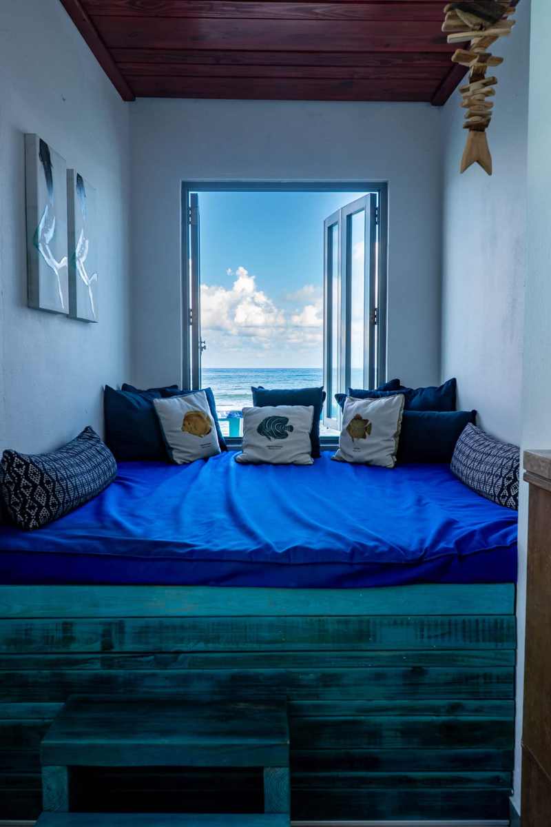 Bedroom with deep blue bedding and nautical pillows