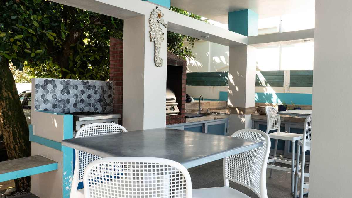 Shaded outdoor dining nook with white table and greenery