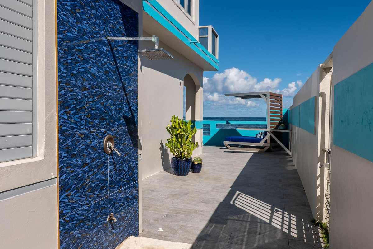 Blue-and-white walkway along the side of the house with ocean views